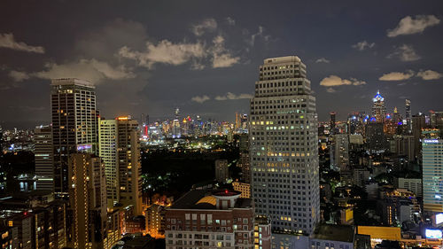 Illuminated buildings in city against sky at night