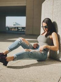 Woman wearing sunglasses sitting outdoors