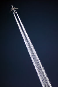 Low angle view of airplane flying against sky