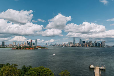 Sea and buildings in city against sky