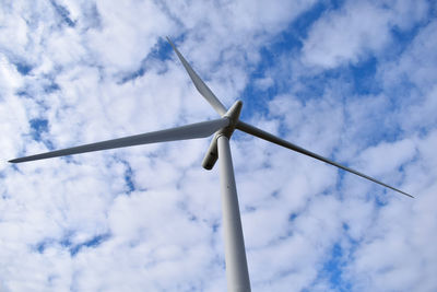 Low angle view of wind turbine against cloudy sky