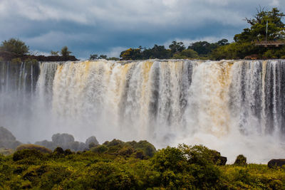 Scenic view of waterfall against sky