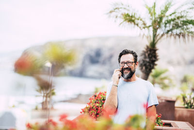 Man photographing with mobile phone standing outdoors