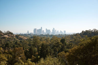 View of trees and buildings against clear sky