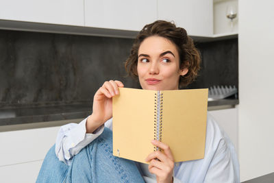 Portrait of young woman reading book