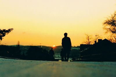 Silhouette of woman against clear sky at sunset