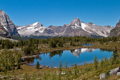 Scenic view of lake and mountains against blue sky
