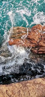 High angle view of wave splashing on rock