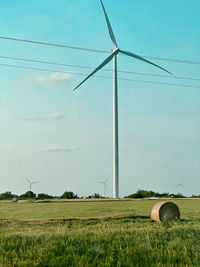 A wind turbine looking over a field in kansas.