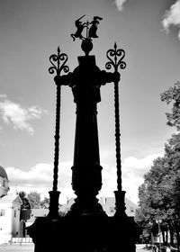 Low angle view of silhouette statue against sky in city