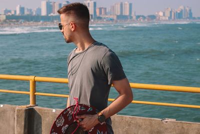 Full length of man standing by railing against sea