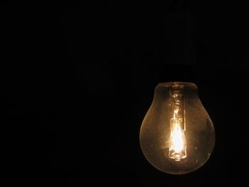 Close-up of lit candle in dark room