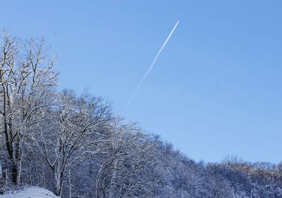 Low angle view of vapor trail against clear blue sky