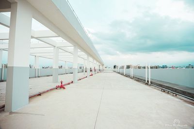 View of empty bridge against cloudy sky