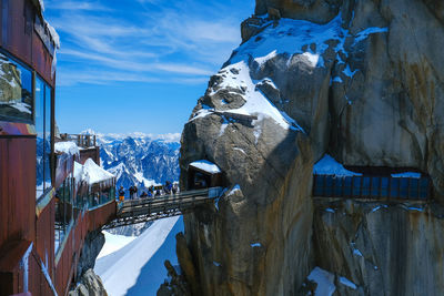 Panoramic view of people on snowcapped mountains against sky