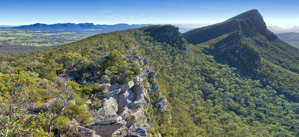 View along heavily forested mountain ridges on sunny day