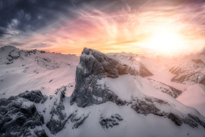 Scenic view of snow covered mountains against sky during sunset