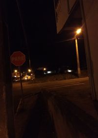 Illuminated street light on road at night