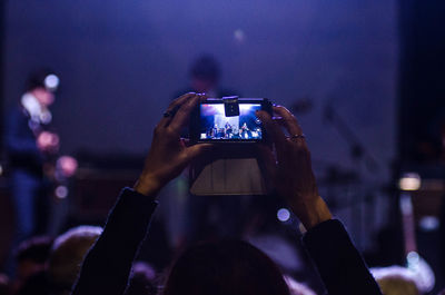 Woman photographing illuminated cityscape