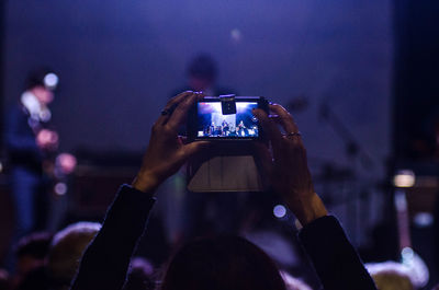 Woman photographing at concert using smart phone