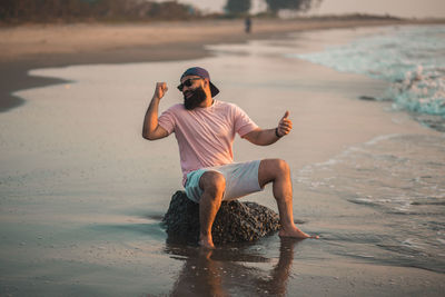 Side view of woman sitting at beach