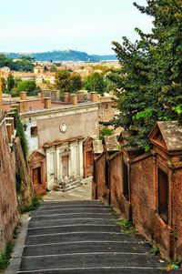 Footpath amidst buildings in town against sky