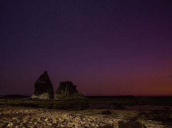 Scenic view of rock formation against sky at night
