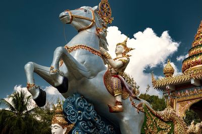 Low angle view of statues on building against sky