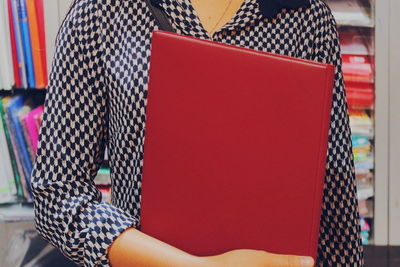 Low section of woman standing by books