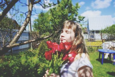 Happy young woman on flower tree against sky