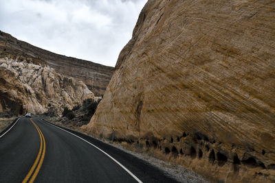 Road leading towards mountains against sky