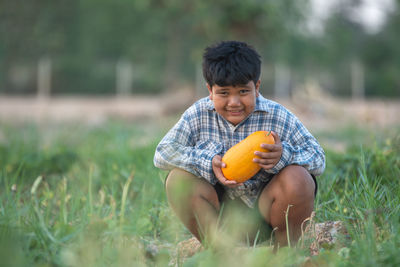 Boy holding ice cream on field