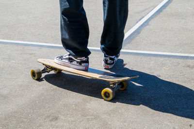 Low section of man skateboarding on road