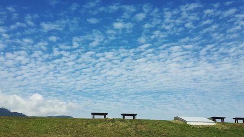Chairs on landscape against sky