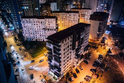 High angle view of illuminated city street and buildings at night