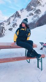 Woman sitting on snowcapped mountain