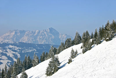 Scenic view of snow covered mountains against clear blue sky