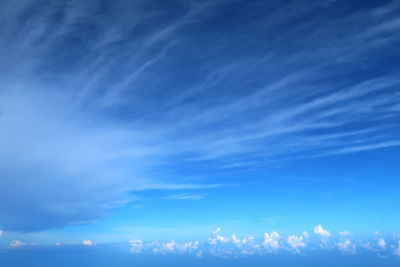 Low angle view of sunlight streaming through clouds
