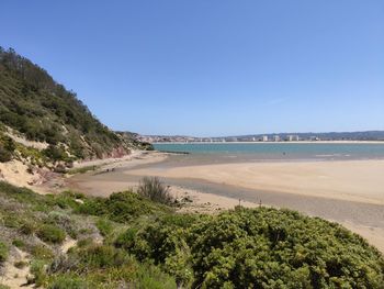 Scenic view of beach against clear blue sky