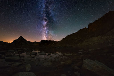 Scenic view of mountains against sky at night