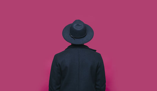 Rear view of person standing against pink background