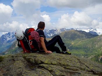 Rear view of man sitting on mountain