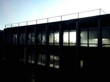 Silhouette building against clear sky during sunset