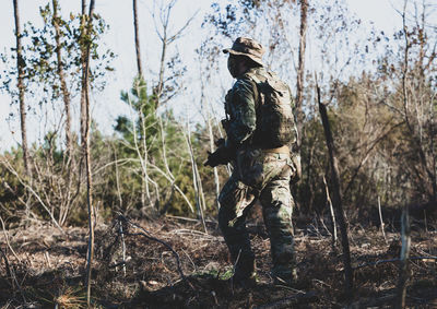 Full length of senior man amidst trees in forest