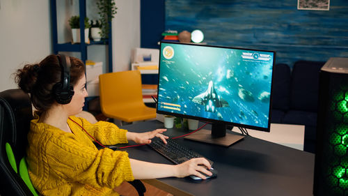 Side view of woman playing game at home