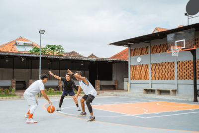 Men playing with ball on basketball court