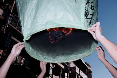 Cropped hands of people holding lantern