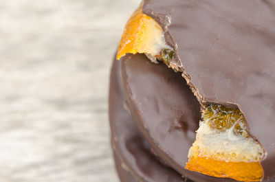 Close-up of chocolates with orange on table