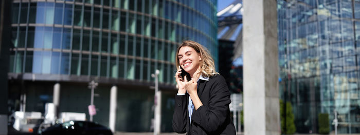 Portrait of young woman standing in city