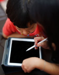 Portrait of boy and girl holding mobile phone